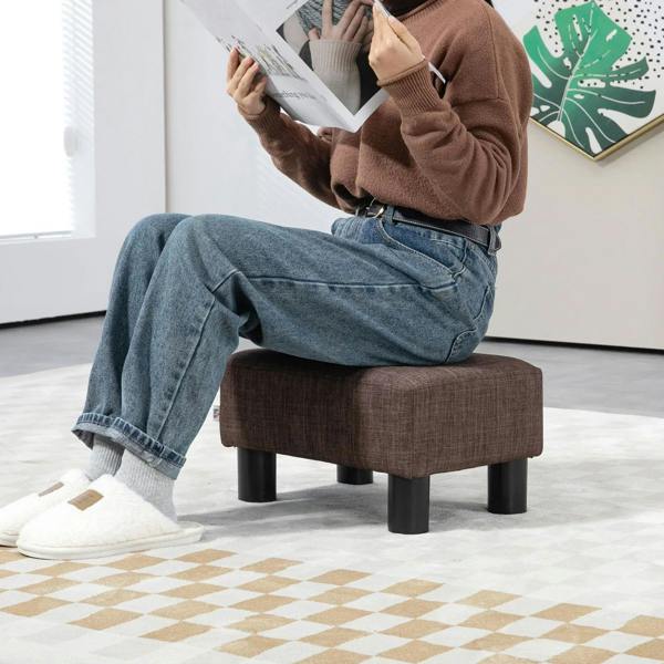 Brown linen ottoman cube with four black legs, cushioned top for sitting