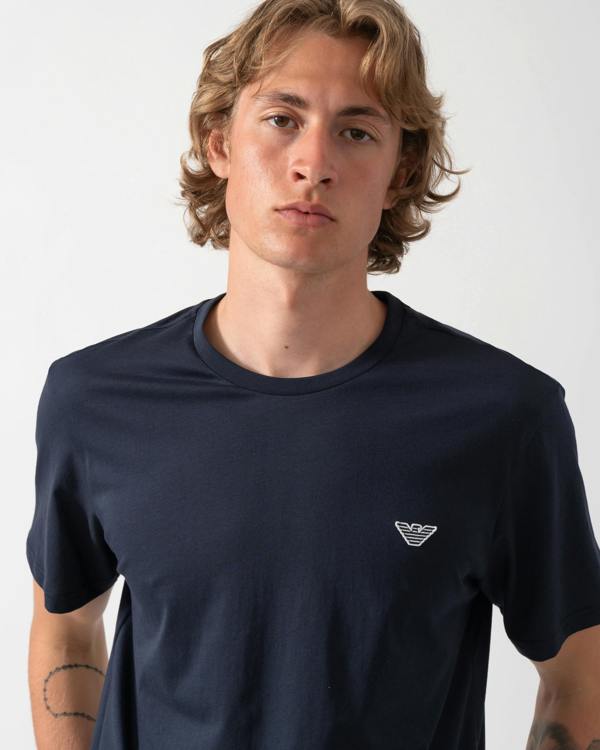 close up shot of a model wearing an Emporio Armani Mens Beach T-Shirt with Eagle Logo in Armani Blue