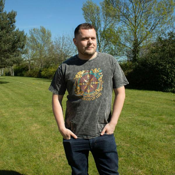 Charcoal T-shirt on model outdoors, Compass of Life graphic on chest