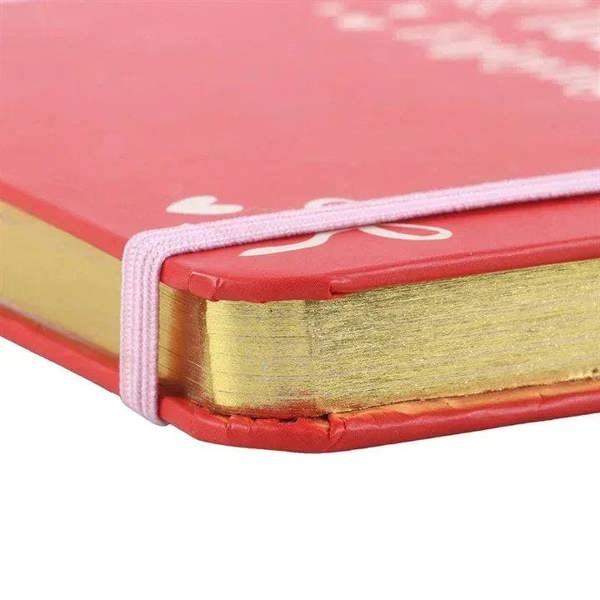 Red A5 notebook corner with white elastic strap and gold-toned edge binding