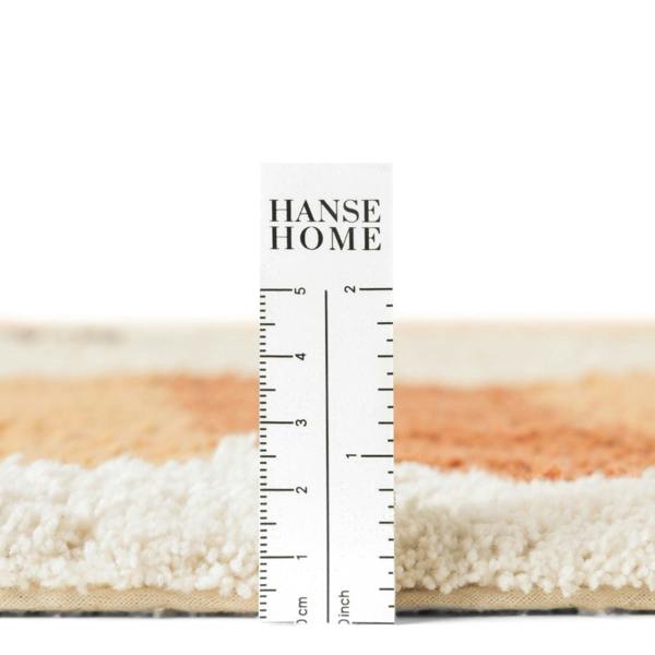 Close-up of a rug with a ruler for scale, featuring 'HANSE HOME' branding.
