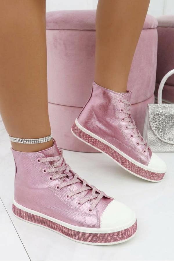 Pink high-top sneakers worn with white socks on a light background