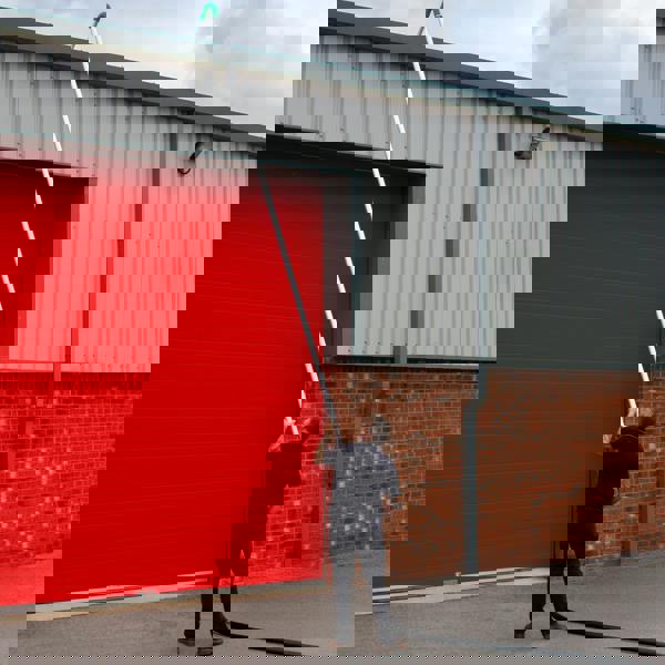 80L wet and dry vacuum with gutter vacuum poles, 5m hose, and a user extending the pole towards a high building wall