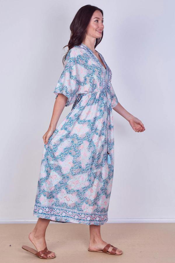 Woman wearing a floral dress against a plain background