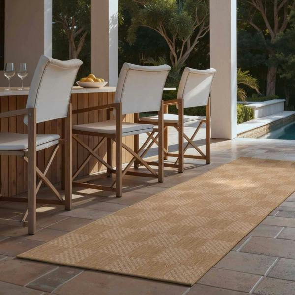Outdoor patio setting with wooden chairs and a rug on a tiled floor.