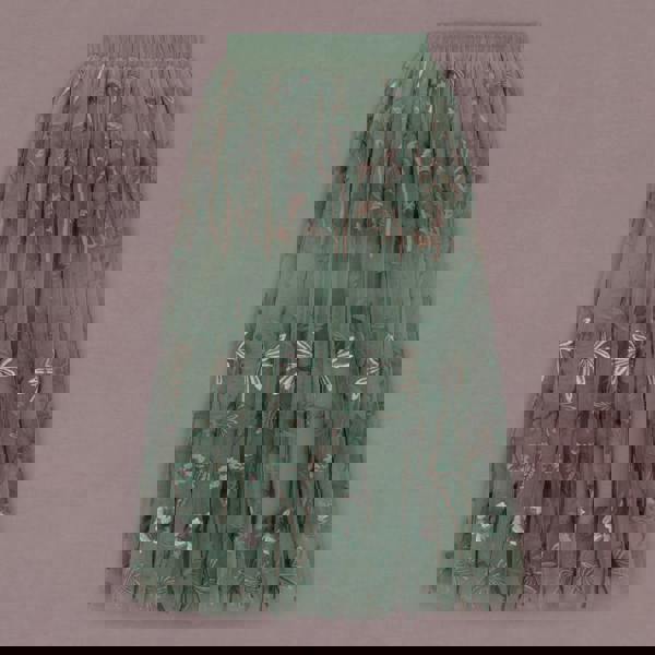 Green pleated skirt with floral pattern on a pink background