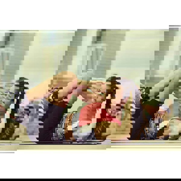 Woman and man performing  Ab Crunches whilst wearing Reebok Ankle Weights - 1kg 