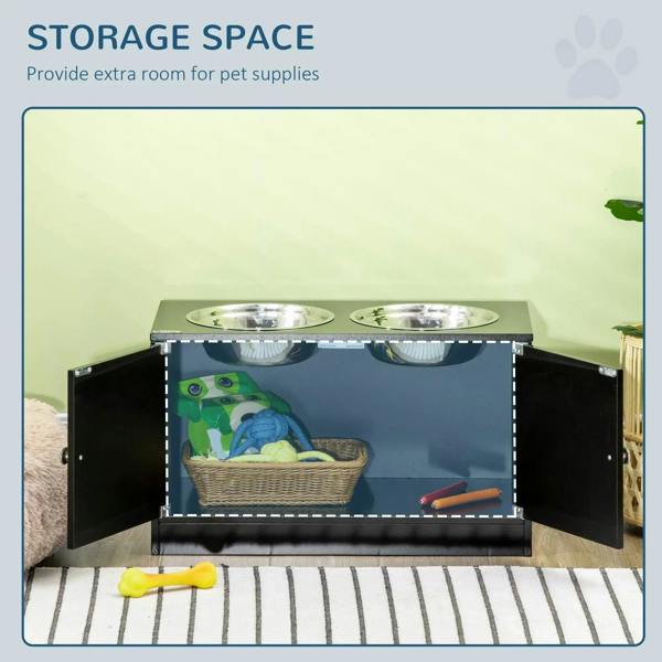 Black raised pet feeder with two stainless bowls; open storage compartment for pet supplies.