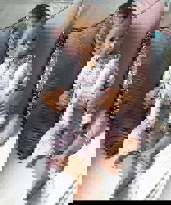 Baby Girl hugging Celeste Unicorn Pull Along Toy without wheels 