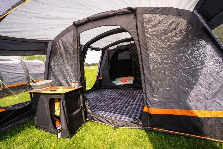 The porch area of the Discovery 6 Berth Inflatable Tent with an OLPRO camp kitchen inside