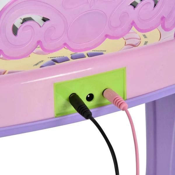 Pink mini electronic keyboard audio jack with black and red cables plugged in
