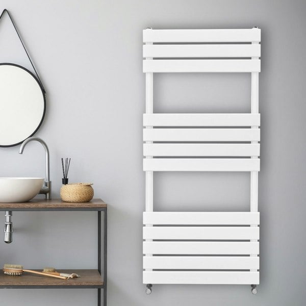 Flat panel towel radiator in sleek white finish, featuring horizontal slats, mounted on a modern bathroom wall above a wooden shelf