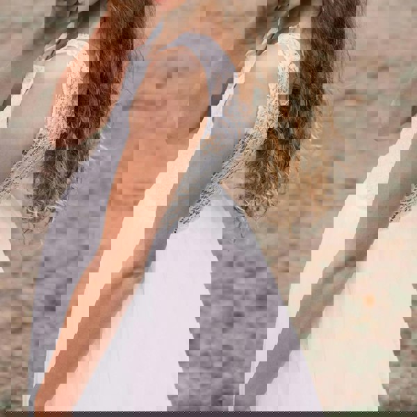 girl wearing a white lace dress against a blurred natural background