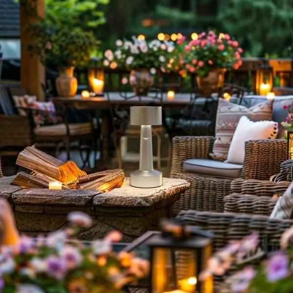 Silver cordless table lamp for outdoor use with cylindrical shade and warm glow