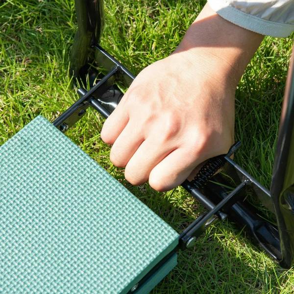 Close-up of hand gripping a garden kneeler seat with dark green cushioned pad
