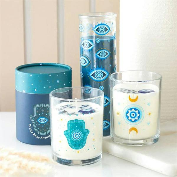 Multi-candle display with teal starry blue jar candle and clear glass candles featuring hamsa emblems