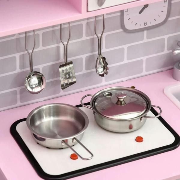 Silver pots and pan on black cooktop of pink kids kitchen playset