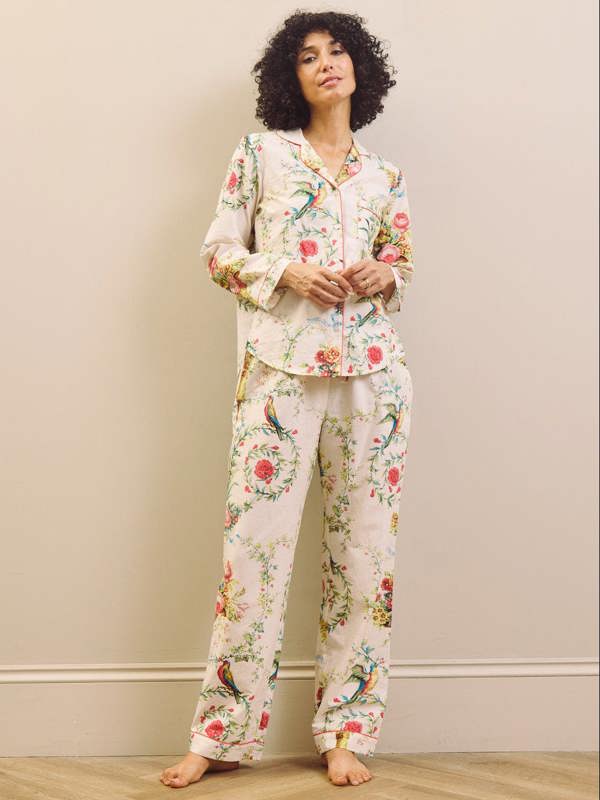 Woman wearing a floral pyjama set against a plain background
