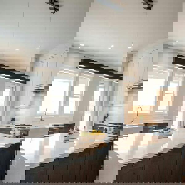 Black hanging bar light above a kitchen island in a modern home