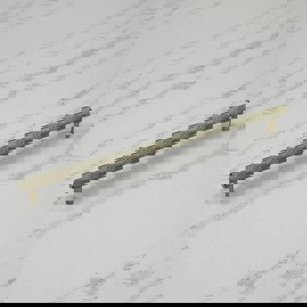 An antique brass reeded T-bar handle