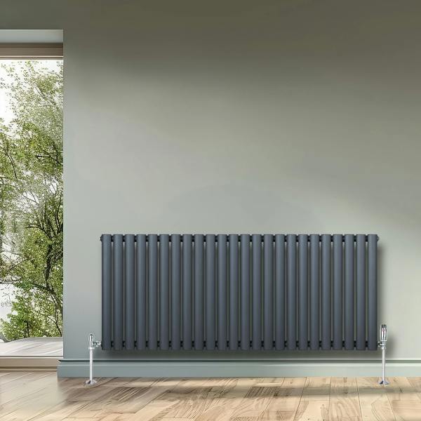 Oval single column radiator in anthracite grey, 600mm x 1440mm, featuring sleek vertical lines and chrome valves against a neutral wall