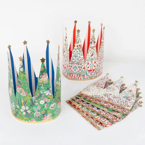 Two assembled Liberty print paper crowns standing next to a stack of flat-packed crowns on a white background