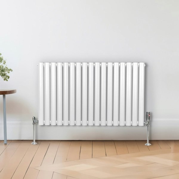 White oval column radiator, 600mm x 1020mm, featuring sleek vertical lines and a glossy finish, mounted on the wall in a modern room