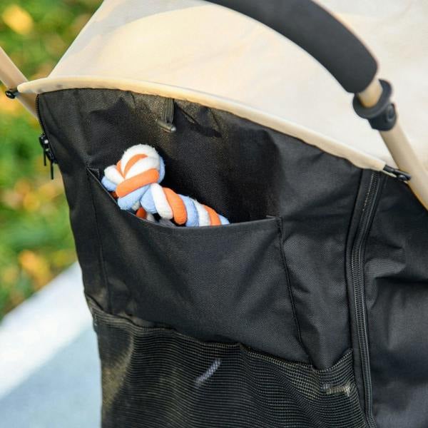 Side storage pocket on khaki and black pet stroller holding a plush toy