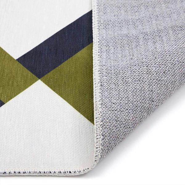 Close-up of a geometric-patterned rug with green, navy, and gray colors on a white background.