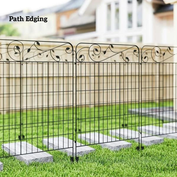Black metal vegetable fence with scroll top and grid panels, staked along garden edge