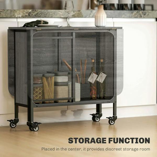 Grey drop-leaf dining table with black frame and open storage compartment on caster wheels