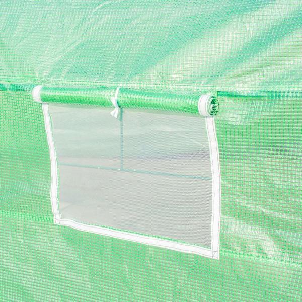 Close-up of green greenhouse side window with mesh frame and clear panel