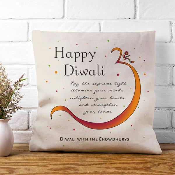 A cream textured linen cushion cover printed with a vibrant orange Om symbol, festive blessings, and 'Diwali with the Chowdhurys' written at the base.