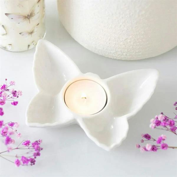 White butterfly tealight candle holder with round cup for a lit candle