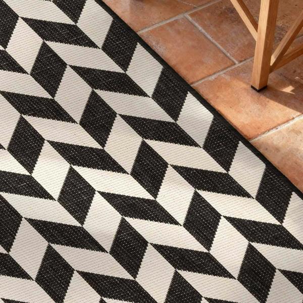 Black and white geometric patterned rug on a tiled floor