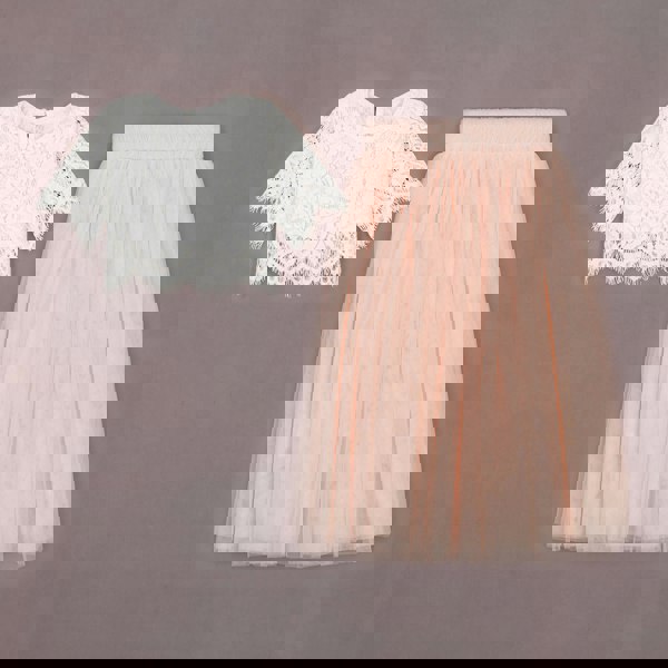 White lace top and pink tulle skirt on a gray background