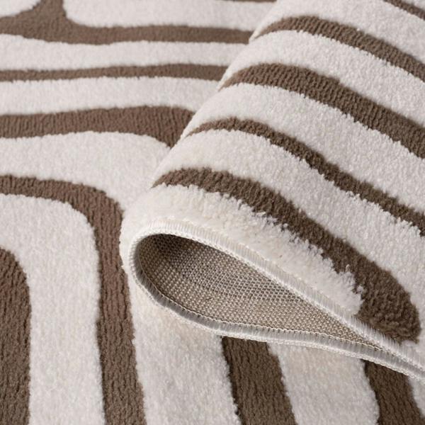 Close-up of a textured rug with brown and beige stripes
