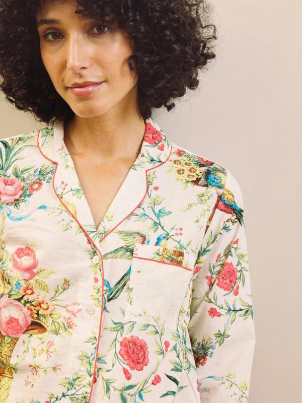Woman wearing a floral capri pyjama set against a plain background