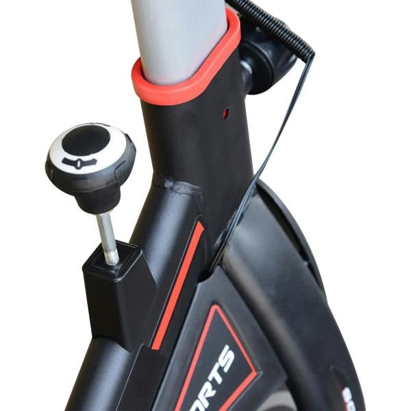 Close-up of handlebar control and red-accented frame on black exercise bike