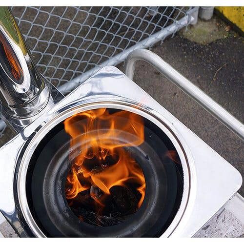 Close-up of a wood stove burner with flames inside