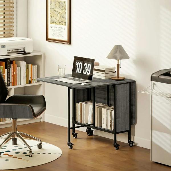 Grey drop-leaf dining table with black frame, open storage shelf, and wheeled feet