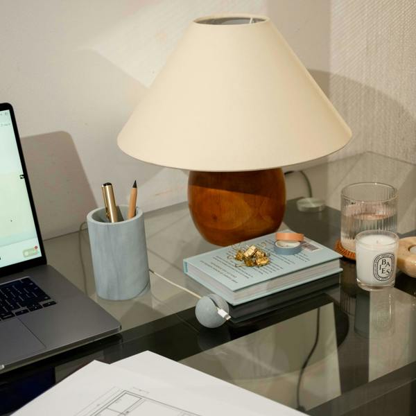 Desk with laptop, lamp, books, and other items in a home office setting