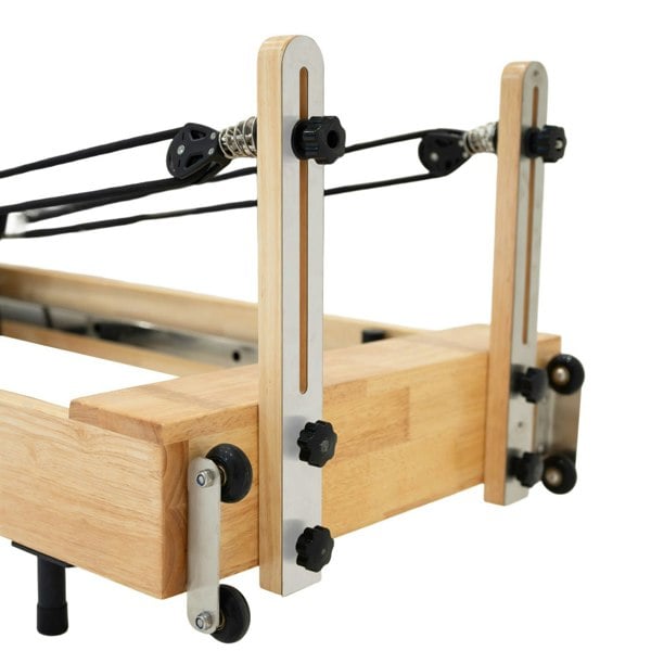 Oak Pilates reformer machine featuring sturdy wooden frame, adjustable straps, and sleek metallic components for optimal performance