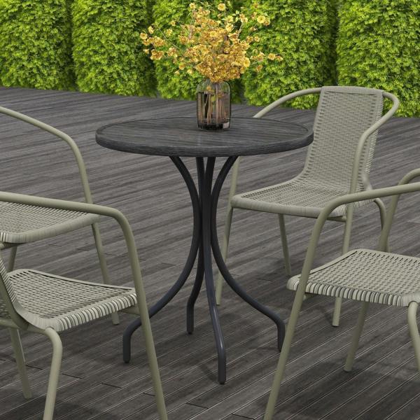 Round grey outdoor table with slatted top and curved legs beside chairs