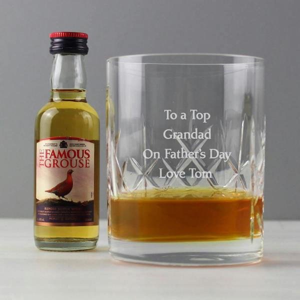 A personalised cut crystal whisky tumbler engraved with a custom message, displayed next to a 5cl whisky miniature and a silver presentation gift box.