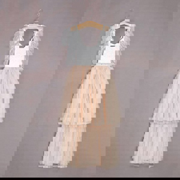 Two-tone dress with white top and beige skirt on a hanger against a gray background