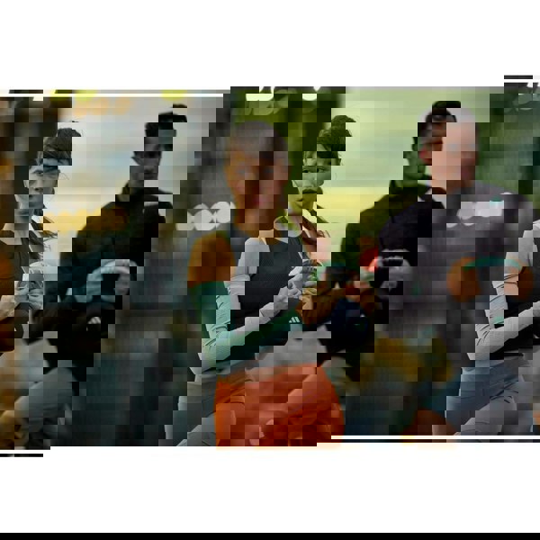 Two people in athletic wear standing outdoors with a blurred cityscape background