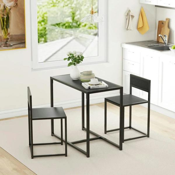Black rectangular dining table with steel frame and two matching chairs in kitchen