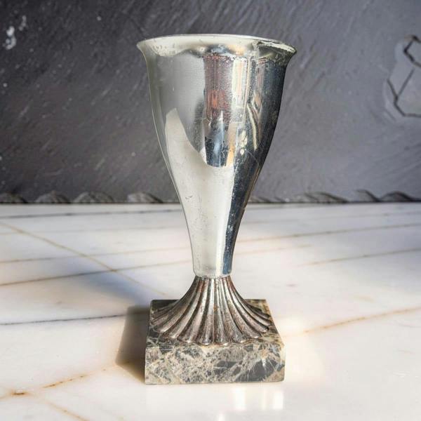 Silver trophy on a marble surface with a dark background