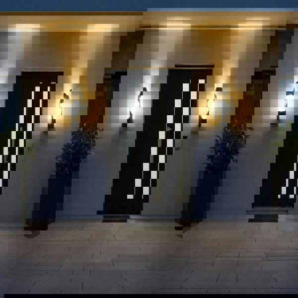 black external wall lantern mounted either side of the entrance door of a modern home 